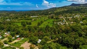 A lush green landscape with streams and a distant view of the coast in Dominical, Costa Rica.