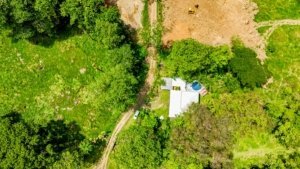 Aerial view of a renovated Costa Rican-style home with streams and lush greenery.