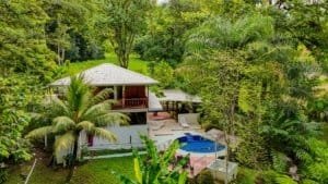 Fully renovated Costa Rican-style home with pool, surrounded by lush greenery and streams.