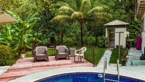 Outdoor pool area with seating and lush tropical garden in Dominical.