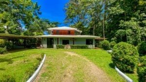 Fully renovated Costa Rican-style home with streams on both sides and lush greenery.