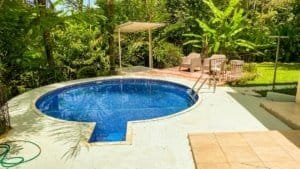 Beautiful Costa Rican home with a pool, lush greenery, and streams on both sides.