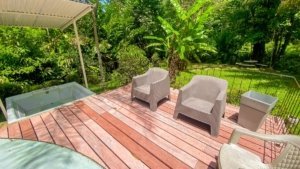 Outdoor deck with chairs, hot tub, and lush greenery in Dominical.