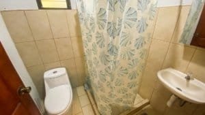 Bathroom of a fully renovated Costa Rican-style home with shower and sink.