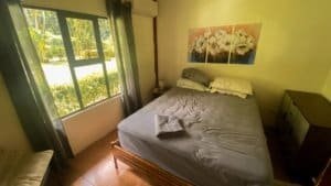 Cozy bedroom with stream view and natural light in Dominical.