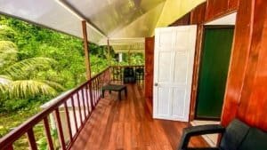 Balcony of a Costa Rican-style home with wooden flooring and lush greenery.