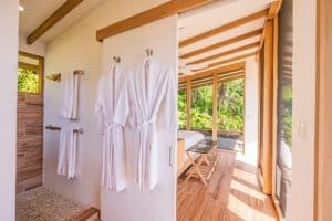 Elegant bathroom with robes and rainforest view in Costa Rica luxury estate.