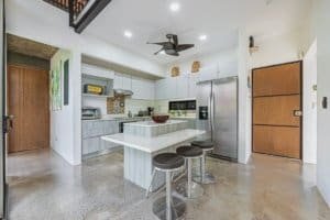Bright, modern kitchen with white cabinets, stainless steel appliances, and a kitchen island.