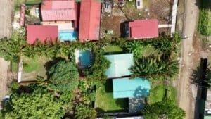 Aerial view of a property with a house, pool, and lush greenery in Dominical.