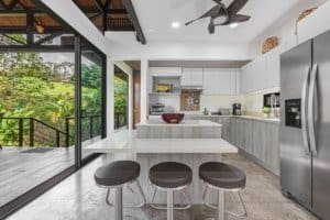 Contemporary kitchen with white cabinets, stainless steel appliances, and outdoor view.