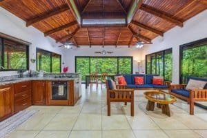 Spacious tropical villa living room with wooden ceiling and jungle views.