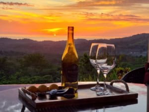 Beautiful sunset over mountains with wine and snacks on a terrace in Dominical.