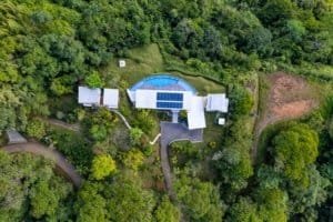 Aerial view of a modern estate with pool surrounded by lush jungle in Dominical.