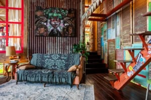 Vibrant, eclectic interior with wooden walls, colorful shutters, and artwork.