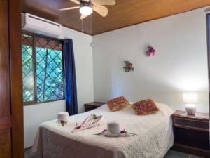 Comfortable bedroom with ocean view, decorated with fish wall art.