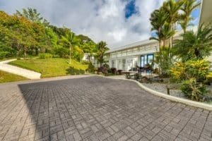 Elegant entrance with lush tropical landscaping and paved driveway in Dominical.