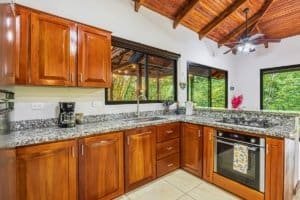 Modern kitchen with wooden cabinets and granite countertops in Dominical, Costa Rica.