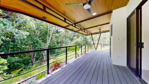 Spacious balcony with wooden ceiling and lush forest view in Dominical.