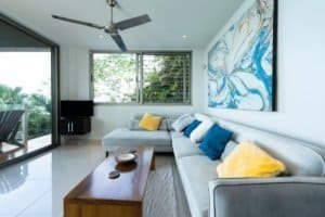 Bright living room with large windows, colorful cushions, and ocean view.