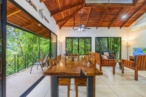 Spacious living room with large windows overlooking lush jungle in Costa Rica.