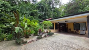 Costa Rican home with tropical garden, outdoor patio, and lush greenery.