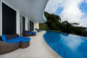 Modern poolside lounge with curved architecture and jungle views in Dominical.