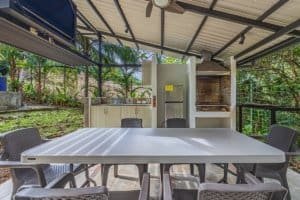 Covered outdoor dining space with table, chairs, and barbecue in Dominical.