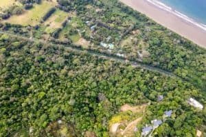 Aerial view of lush forest, beach, and coastal estate in Dominical, Costa Rica.