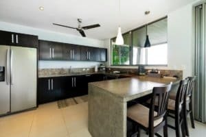 Contemporary kitchen with black cabinets, island, and large windows in Dominical.