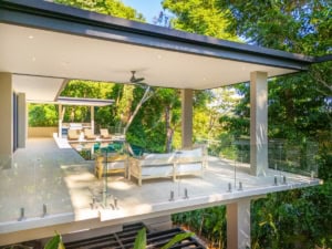 Modern tropical home with outdoor lounge, infinity pool, and lush greenery.