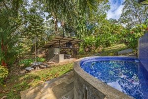 Lush tropical garden with pool and outdoor kitchen in Dominical, Costa Rica.