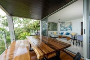 Spacious balcony overlooking lush jungle with outdoor dining area.