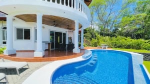 Beautiful pool and patio area of a Costa Rican home with lush greenery.
