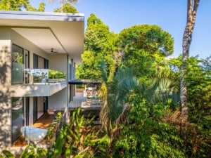 Modern ocean view home with infinity pool and lush tropical surroundings.