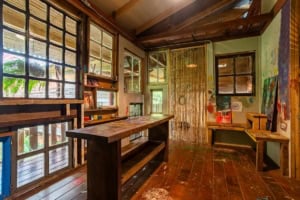 Cozy rustic room with wooden furniture and large windows in Dominical.