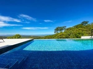 Infinity pool overlooking ocean and lush green landscape in Dominical.