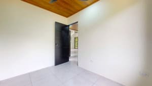 Bright, minimalist room with white walls and wooden ceiling in Costa Rica.