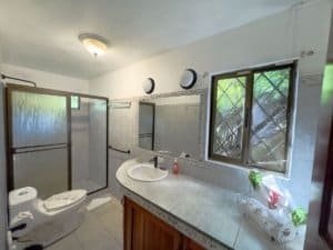 Bathroom in Dominical Costa Rica with shower, toilet, and window view.