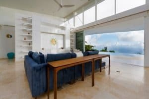 Bright living room with large windows and ocean view in Dominical, Costa Rica.