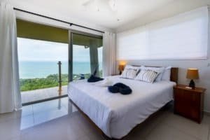 Bright bedroom with ocean view, balcony, and modern decor in Costa Rica.