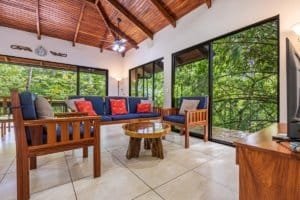 Bright living room with large windows overlooking lush jungle in Dominical.