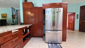 Spacious kitchen with wooden cabinets and stainless steel refrigerator.