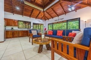 Spacious tropical villa living room with wooden ceiling and large windows.