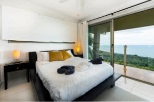 Luxury bedroom with ocean view, balcony, and modern decor in Dominical.