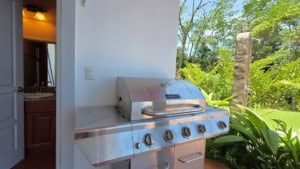 Stainless steel outdoor BBQ grill overlooking lush green landscape.