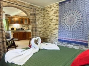 Decorative bedroom with swan towels, tapestry, and stone wall in Dominical.