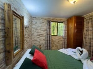 Comfortable bedroom with swan towels, window view, and rustic decor.