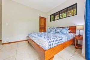 Comfortable bedroom with wooden furniture and jungle view in Dominical.
