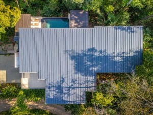 Aerial view of a tropical luxury home with infinity pool and lush greenery in Dominical.