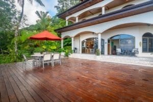 Elegant Costa Rican villa with spacious wooden deck and outdoor dining area.